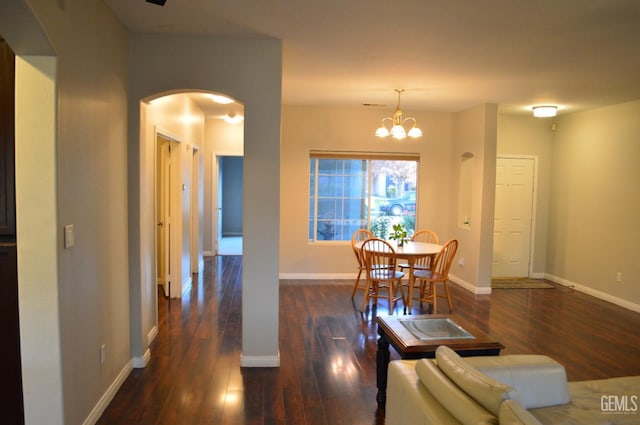 dining area featuring hardwood / wood-style flooring, baseboards, and arched walkways