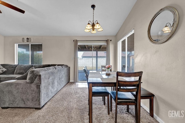 dining area with baseboards, a textured wall, lofted ceiling, an inviting chandelier, and carpet flooring