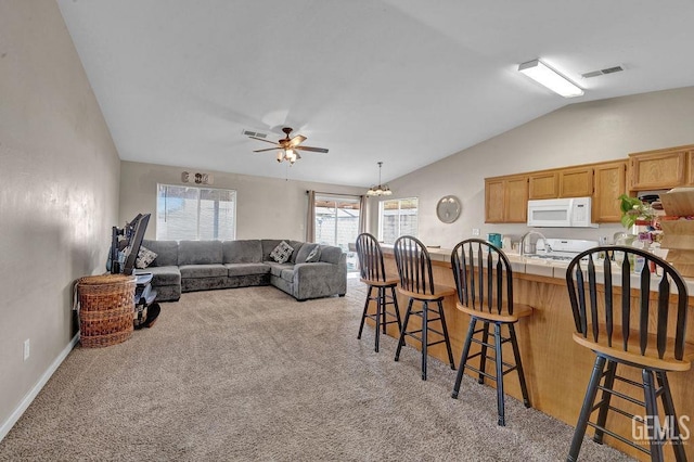 living room featuring light carpet, baseboards, visible vents, a ceiling fan, and lofted ceiling