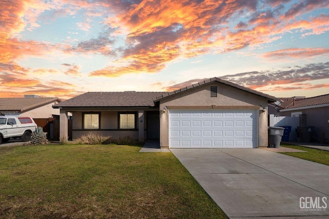 single story home with an attached garage, concrete driveway, a front yard, and stucco siding