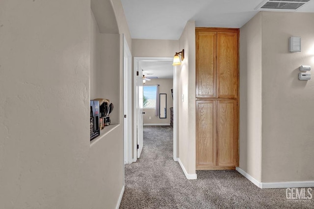 hall featuring carpet, visible vents, and baseboards