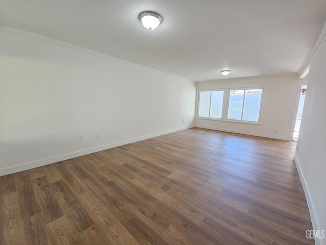 unfurnished room featuring dark hardwood / wood-style flooring and ornamental molding