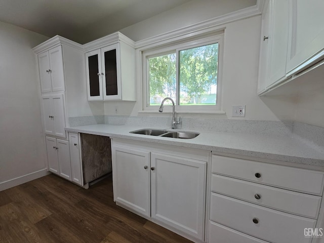 kitchen featuring light stone countertops, white cabinetry, sink, and dark wood-type flooring