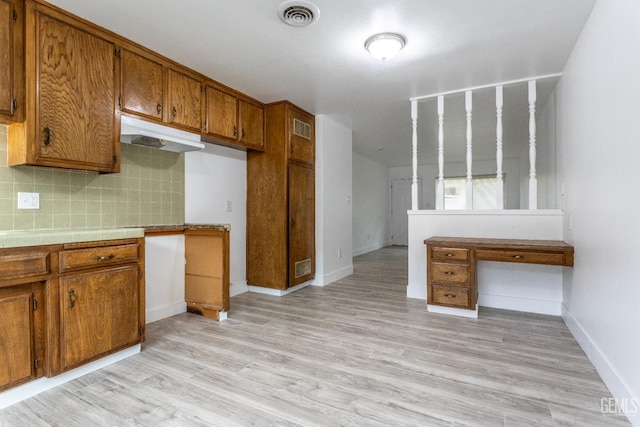 924 Day Ave, Bakersfield, CA 93308 - kitchen with decorative backsplash, visible vents, brown cabinets, under cabinet range hood, and light wood-style flooring