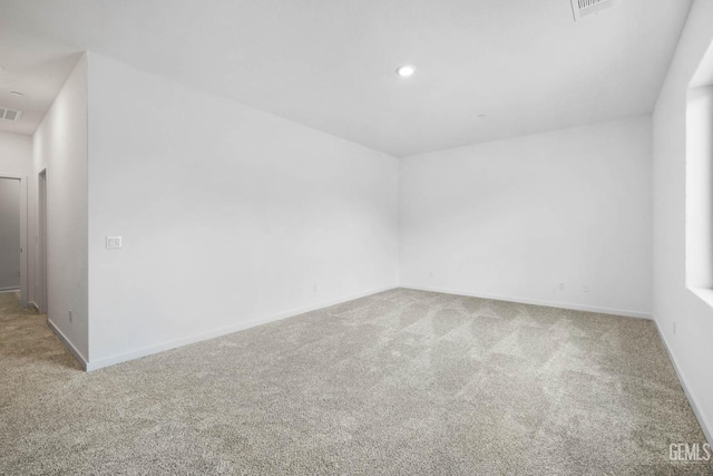 spare room featuring carpet floors, recessed lighting, visible vents, and baseboards