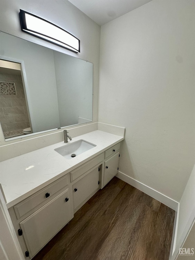 bathroom with vanity, hardwood / wood-style flooring, and toilet