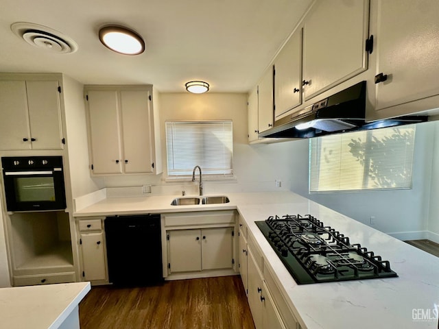 kitchen with dark wood-type flooring, sink, and black appliances