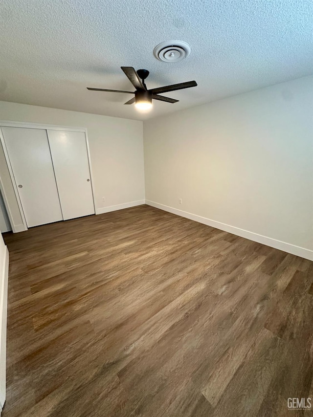 unfurnished bedroom with dark hardwood / wood-style flooring, a closet, and a textured ceiling