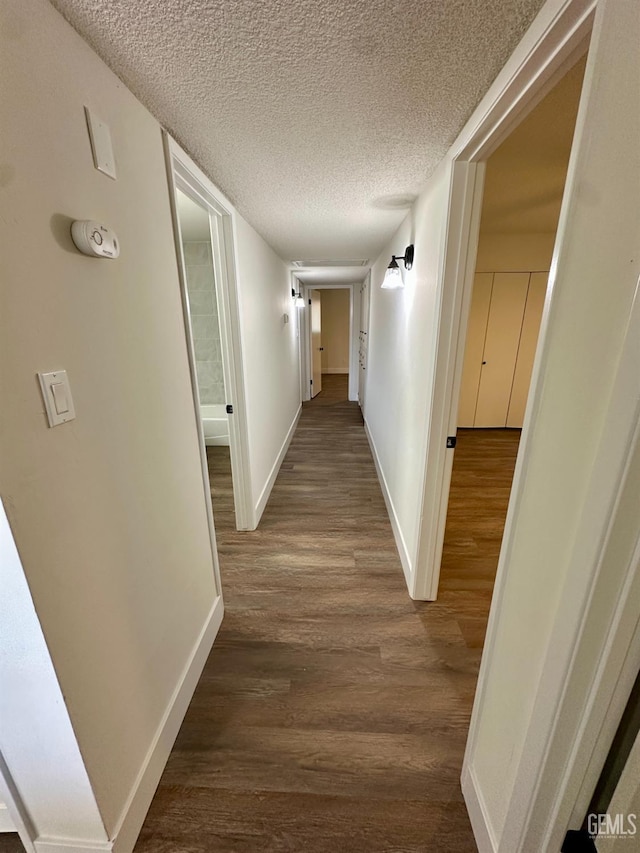 corridor featuring hardwood / wood-style floors and a textured ceiling