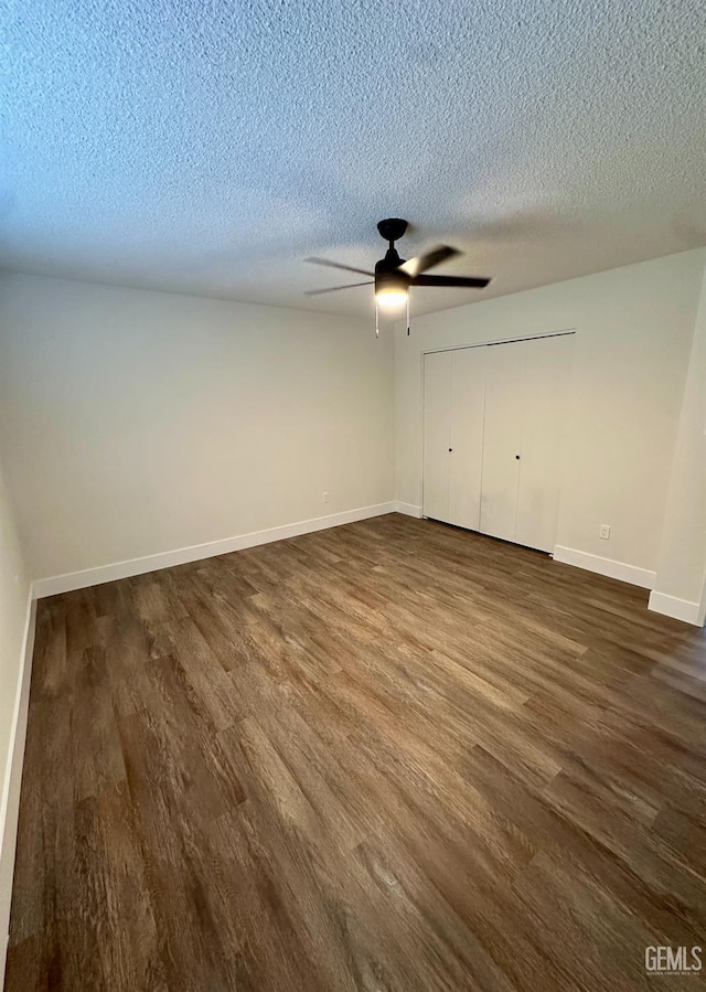 unfurnished bedroom featuring ceiling fan, dark wood-type flooring, a closet, and a textured ceiling