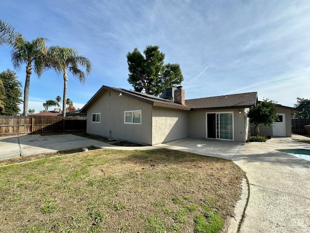 back of house featuring a yard and a patio area