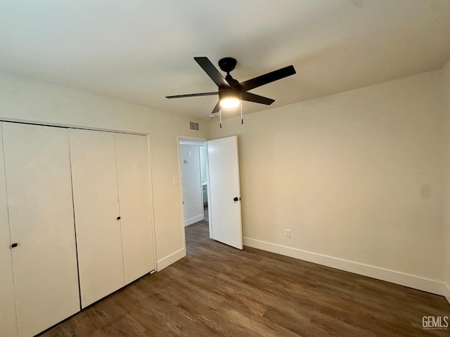 unfurnished bedroom with dark wood-type flooring, ceiling fan, and a closet