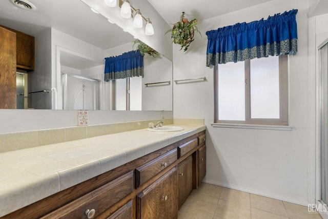 full bathroom featuring a shower stall, vanity, visible vents, baseboards, and tile patterned flooring
