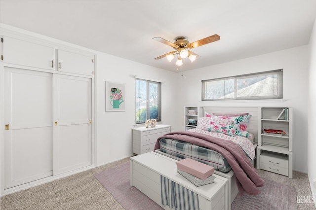 bedroom with a ceiling fan, light colored carpet, and baseboards