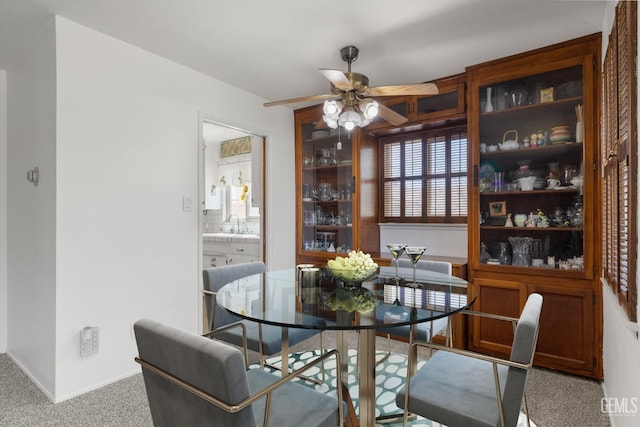carpeted dining area featuring a ceiling fan and a sink
