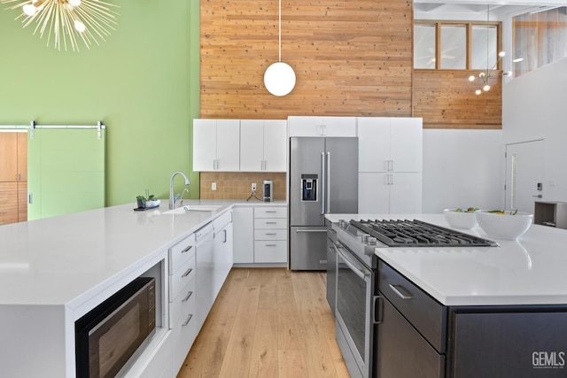 662 Woodland Ct, Arroyo Grande, CA 93420 - kitchen featuring appliances with stainless steel finishes, a kitchen island, white cabinets, a towering ceiling, and light wood finished floors