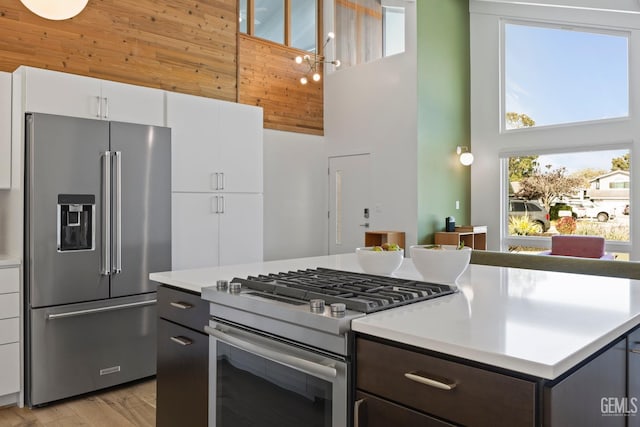 662 Woodland Ct, Arroyo Grande, CA 93420 - kitchen featuring a high ceiling, appliances with stainless steel finishes, wooden walls, light countertops, and a kitchen island