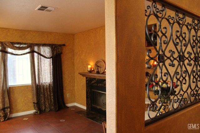 interior space featuring a premium fireplace, visible vents, and baseboards