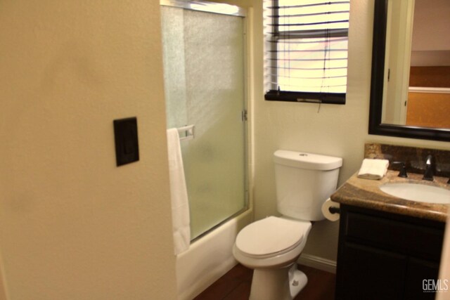 full bath with enclosed tub / shower combo, baseboards, toilet, and vanity