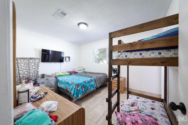 bedroom with light tile patterned floors and a textured ceiling