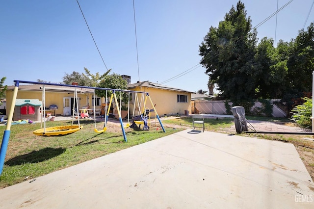 view of front of house featuring a playground, a patio, and a front lawn