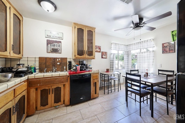 kitchen featuring ceiling fan, tile counters, tasteful backsplash, light tile patterned floors, and black appliances