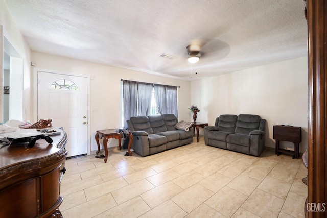 living room with light tile patterned floors, a textured ceiling, and ceiling fan