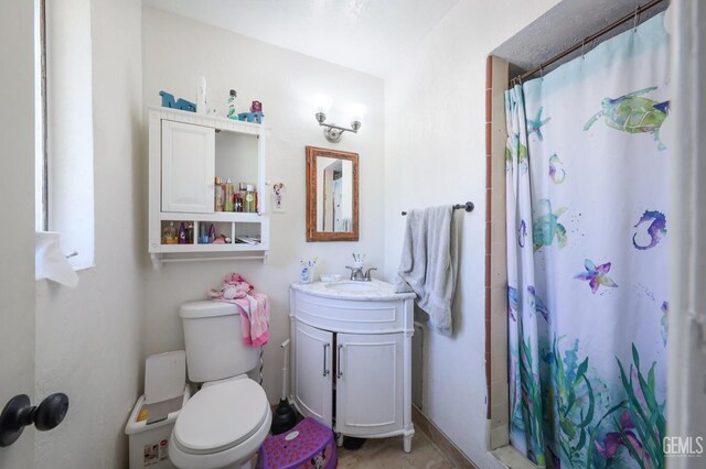 bathroom with a shower with shower curtain, vanity, and toilet