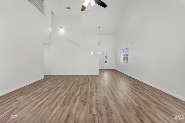 unfurnished living room featuring high vaulted ceiling, wood finished floors, and ceiling fan