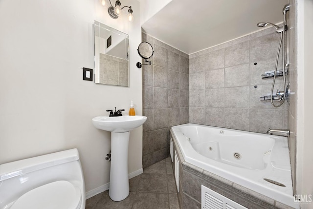 bathroom with tiled shower / bath combo, toilet, and tile patterned floors