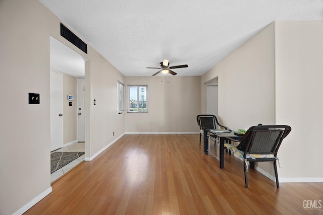 sitting room featuring a textured ceiling, light hardwood / wood-style flooring, and ceiling fan