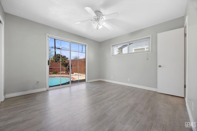 spare room featuring ceiling fan, wood-type flooring, and a textured ceiling