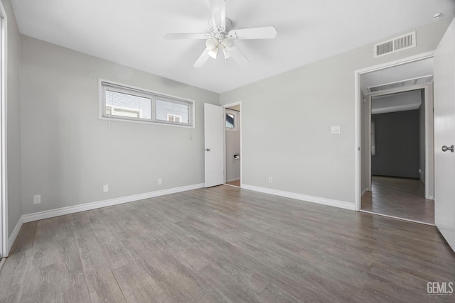 empty room with ceiling fan and hardwood / wood-style floors