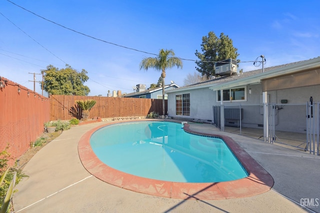 view of swimming pool with central air condition unit and a patio area