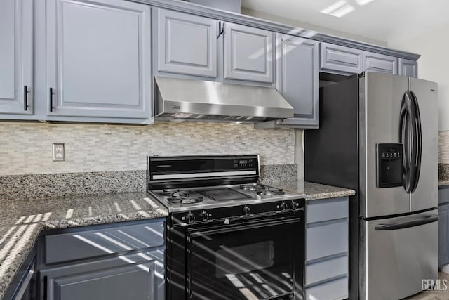 kitchen featuring tasteful backsplash, stainless steel fridge with ice dispenser, dark stone counters, range hood, and gas stove