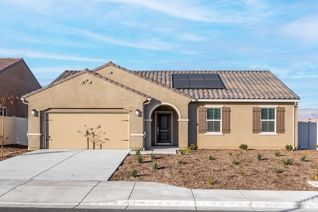 4920 Tachi Ave, Bakersfield, CA 93306 - mediterranean / spanish-style house featuring a tile roof, driveway, a garage, solar panels, and stucco siding