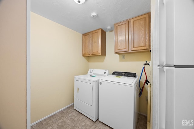 laundry area featuring cabinet space, baseboards, and washing machine and dryer