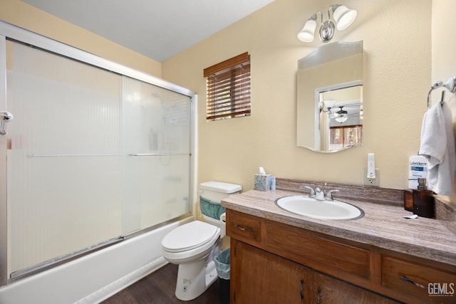 full bath featuring combined bath / shower with glass door, vanity, toilet, and wood finished floors