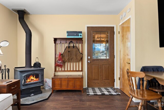 mudroom with dark wood-type flooring and a wood stove