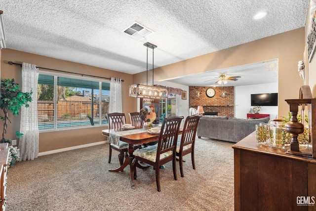 dining room with ceiling fan, light colored carpet, a textured ceiling, and a brick fireplace