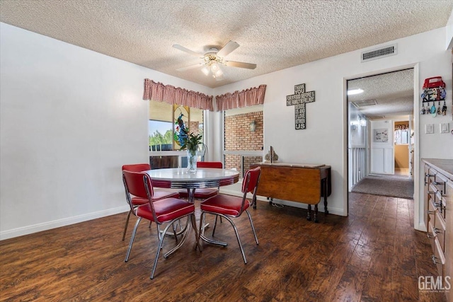 dining area featuring ceiling fan, dark wood-type flooring, and a textured ceiling