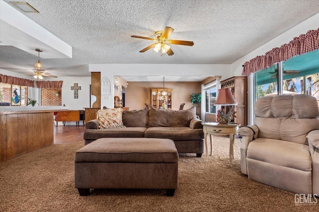 carpeted living room with ceiling fan and a textured ceiling