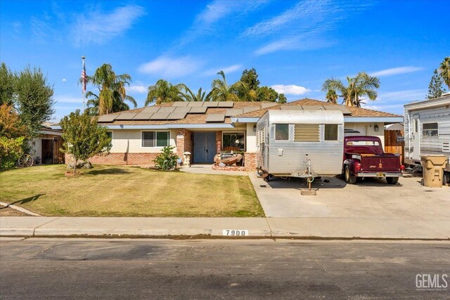 ranch-style house with a front lawn and solar panels