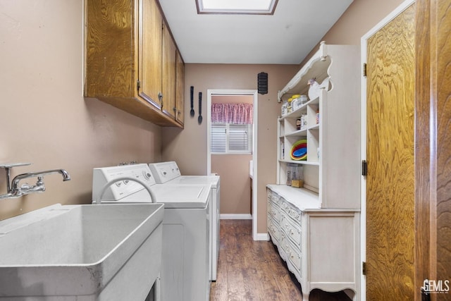 laundry room with cabinets, washer and clothes dryer, dark wood-type flooring, and sink