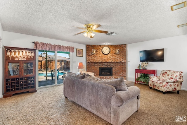 living room with light carpet, a fireplace, ceiling fan, and a textured ceiling