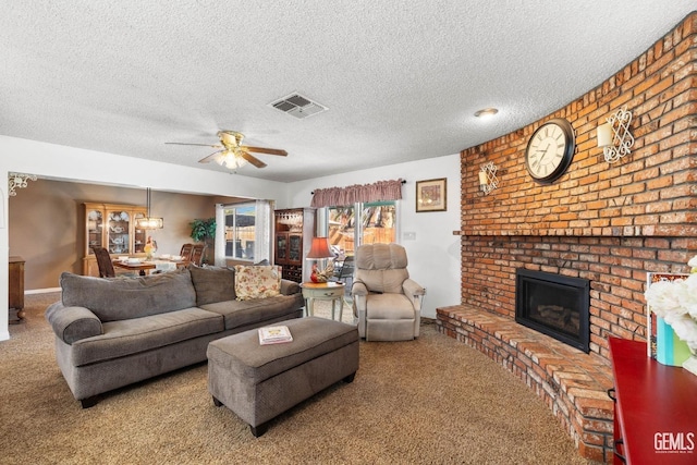 carpeted living room featuring ceiling fan, a fireplace, and a textured ceiling