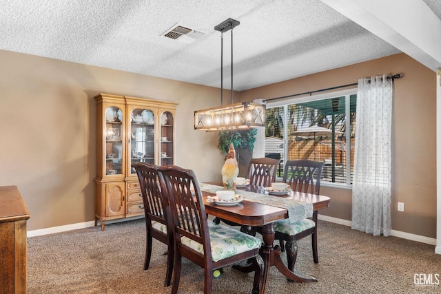 carpeted dining area featuring a textured ceiling