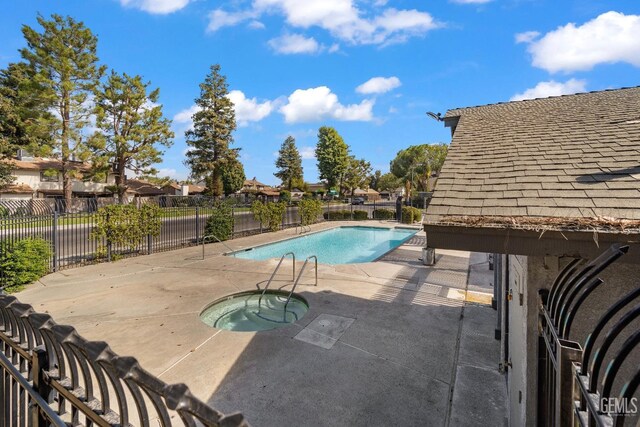 view of pool with a community hot tub and a patio