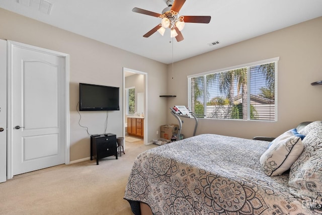 bedroom featuring ceiling fan, ensuite bathroom, and light carpet