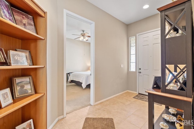 entryway with ceiling fan and light colored carpet